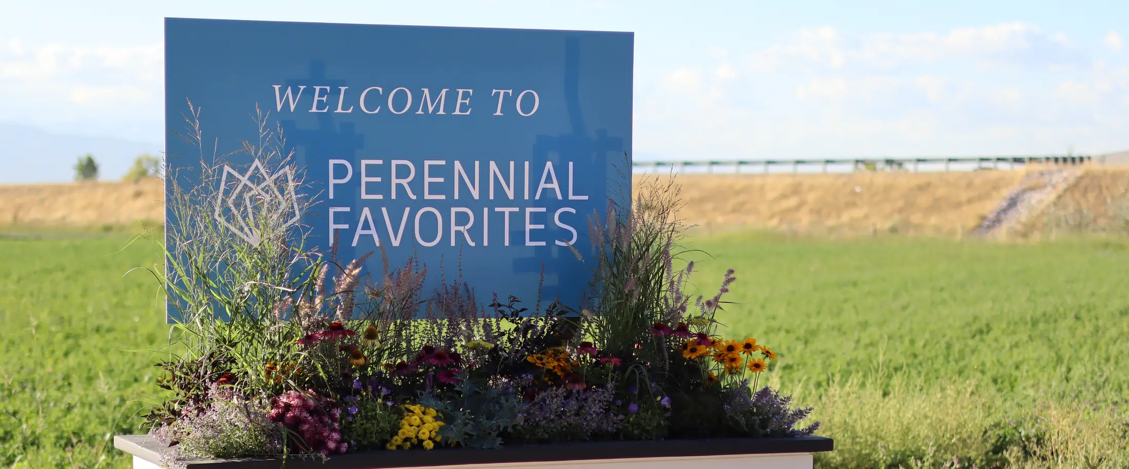 Welcome to Perennial Favorites sign in a planter of perennials and grasses
