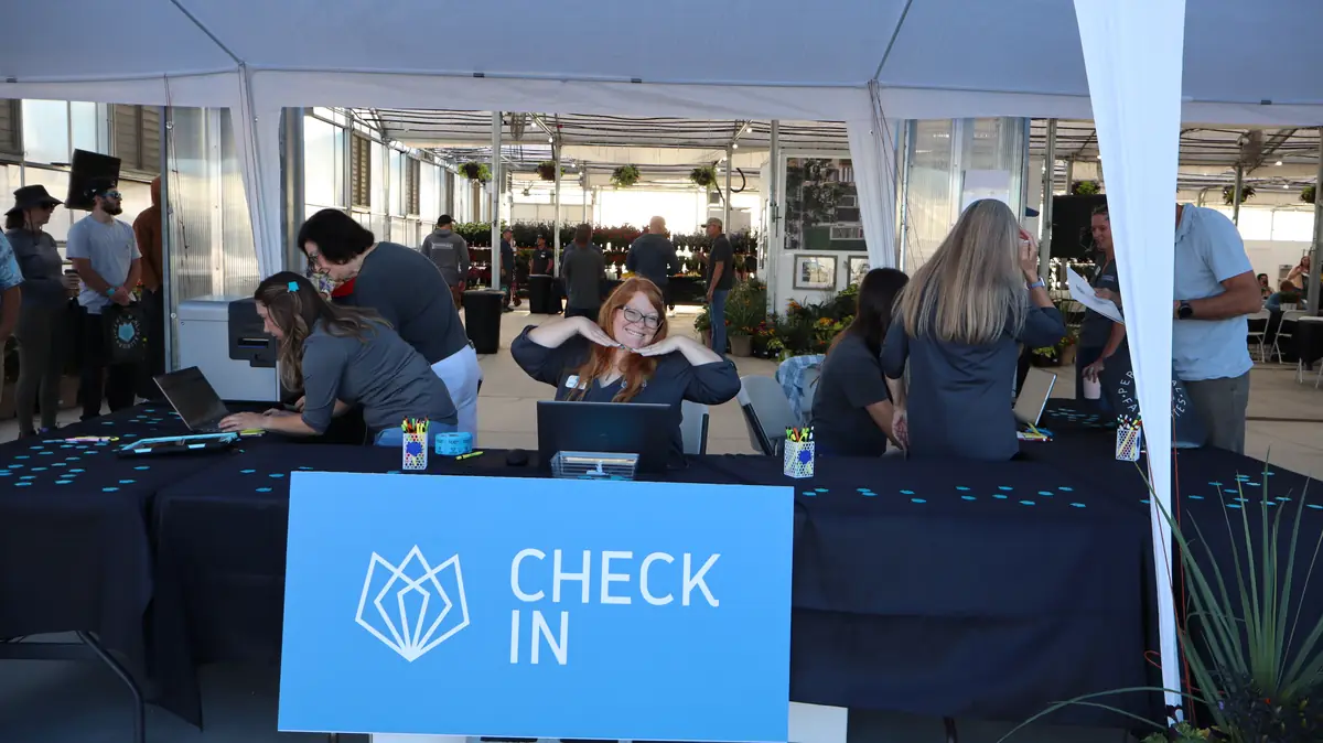 PF staff at the check-in table under the Check In sign