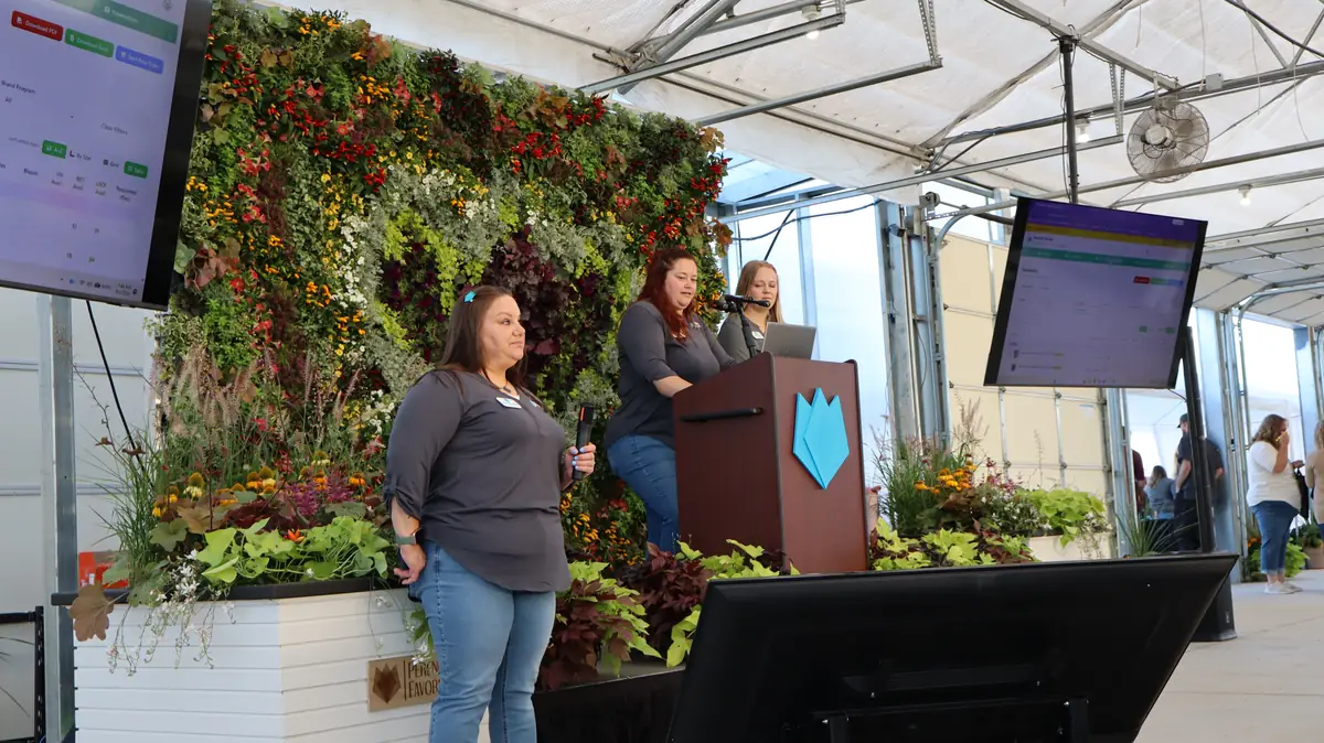 Three PF team members presenting the website demo at the podium