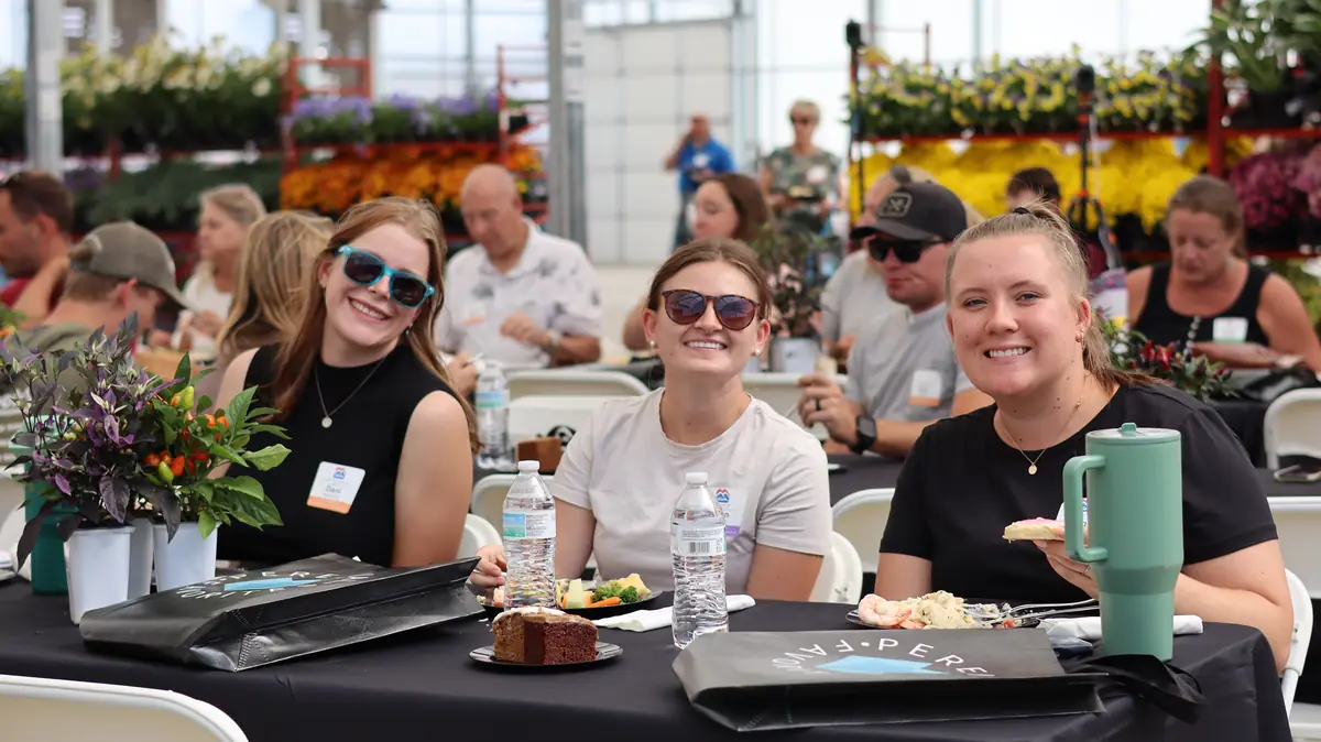 Three guests smiling at their lunch table