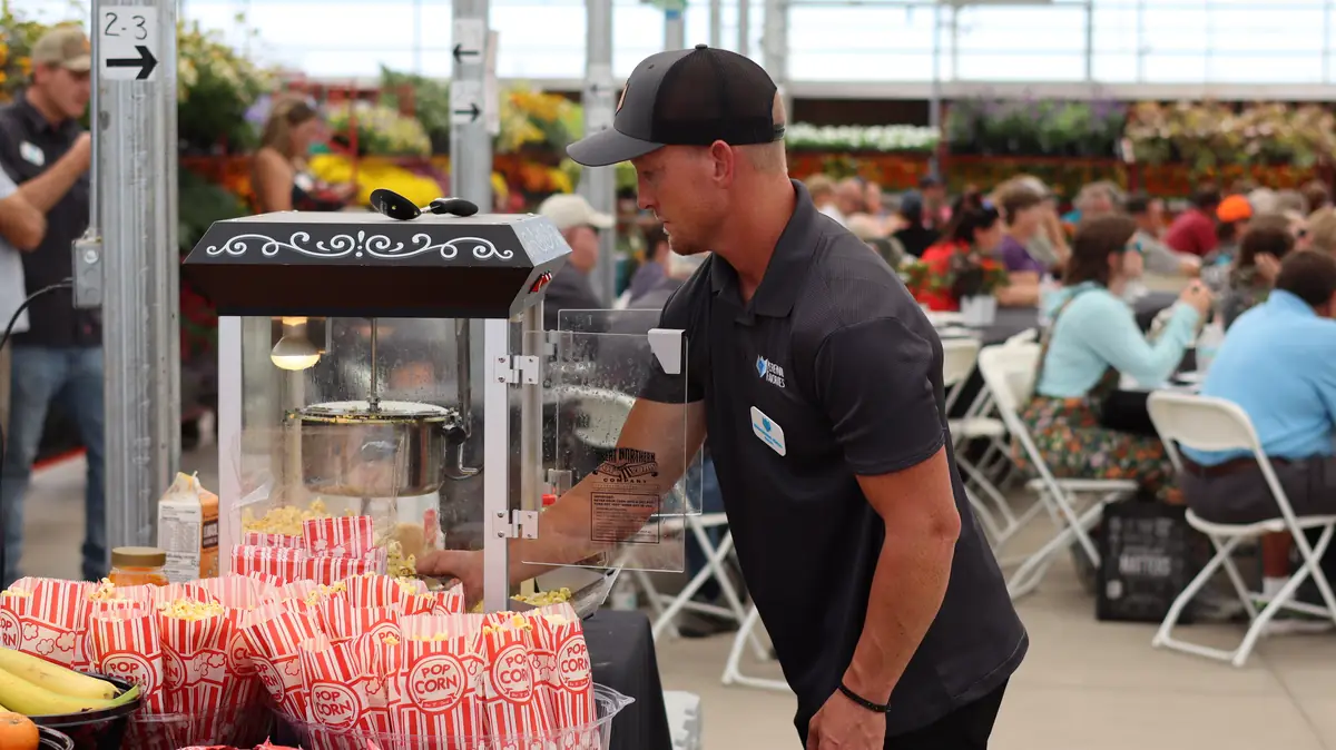 A PF team member filling bags from the popcorn machine
