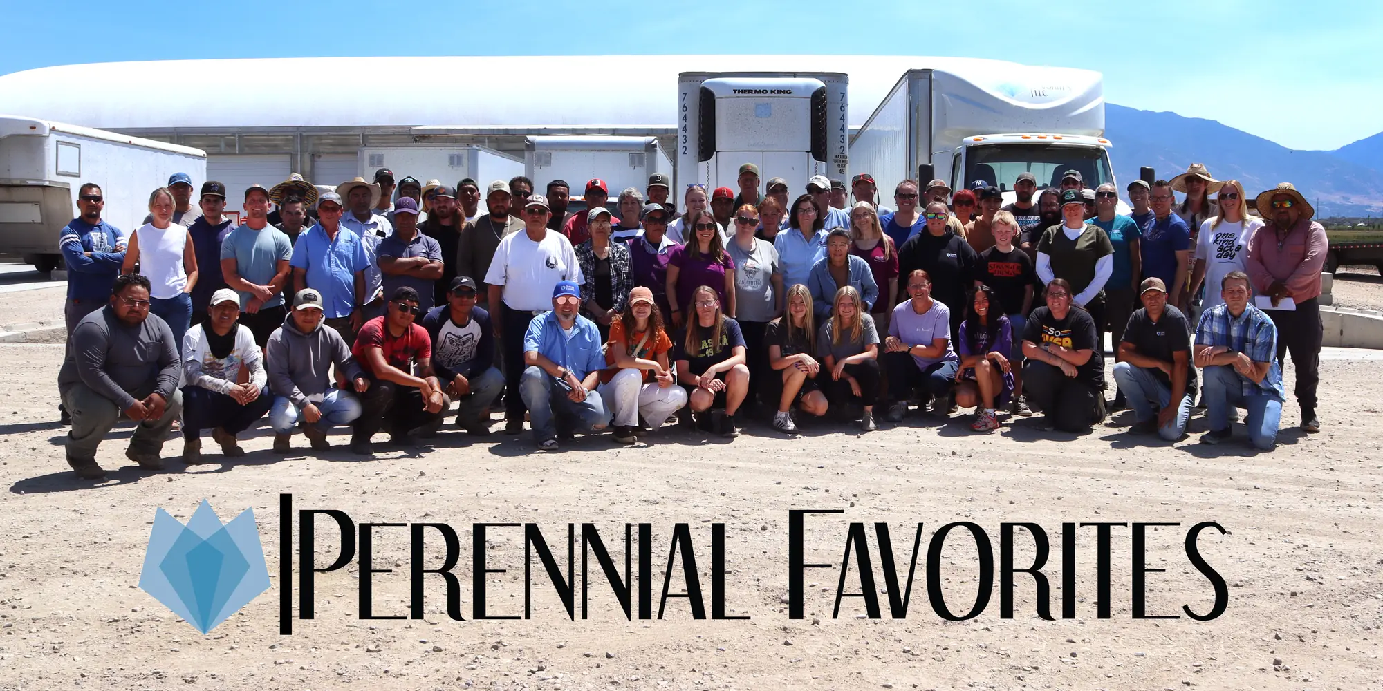 The full Perennial Favorites crew in front of the trucks and greenhouses, with the PF logo