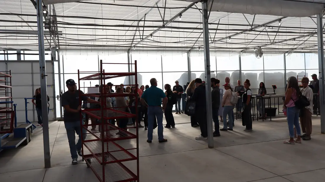 Tour group in the Shipping House with plant racks