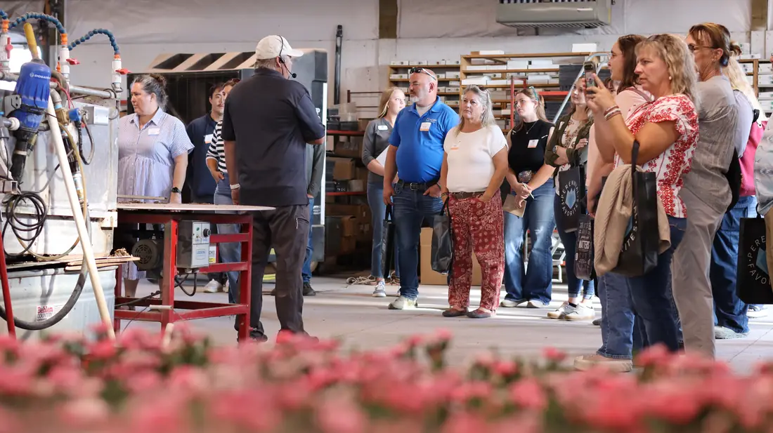 Guests inside production with flowering plants in the foreground