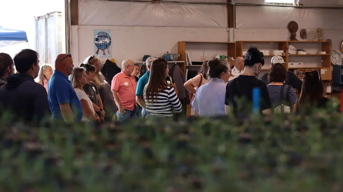 Tour group in production behind trays of young plants